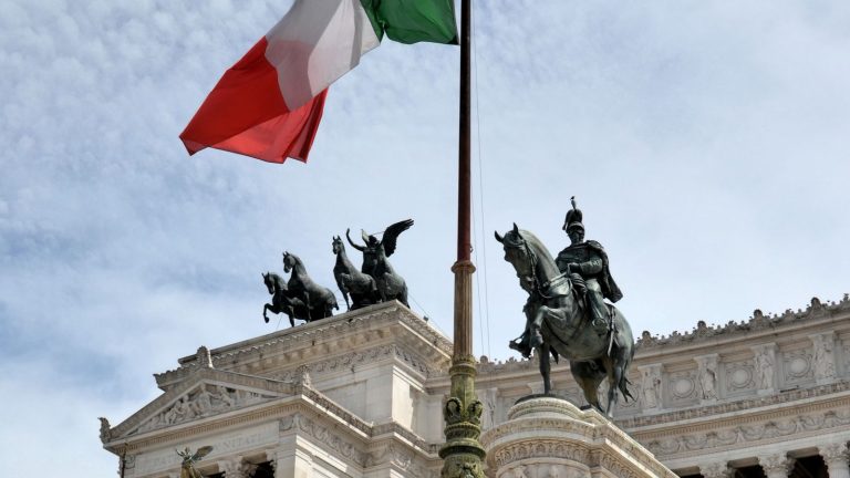 Drapeau italien flottant au-dessus d'un monument de Rome, symbole du débat sur la fleur de CBD en Italie